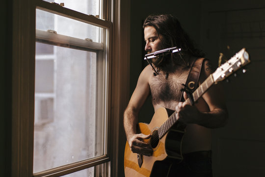 A soulful scruffy musician plays instruments