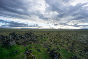 Iceland - Green lowlands and far mountains at dawn with clouds