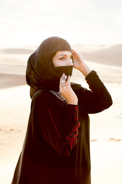 Middle Eastern woman wearing hijab in desert. Dubai.