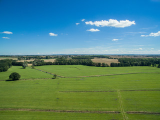 Fototapeta na wymiar Aerial view of beautiful green farmland with blue sky in germany