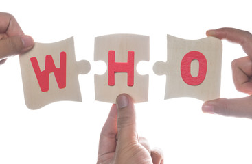 Hand holding wooden jigsaw puzzles with the word "WHO" isolated over white,Jigsaw business idea concept