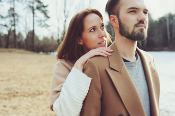 Naklejka premium young happy loving couple walking outdoor in autumn or early spring