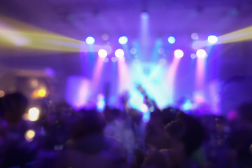 Blur background of concert crowd in front of bright stage lights musics