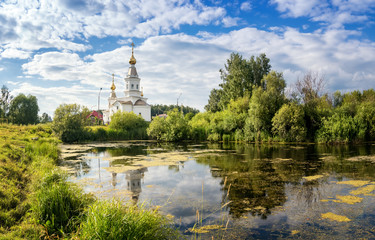 панорама летнего пейзажа с озером и белой церковью на берегу, Россия, Урал, август
