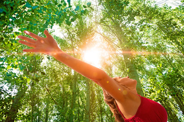 Mujer con los brazos abiertos en paisaje con arboles.Puesta de sol en paisaje de ensueño.Concepto...