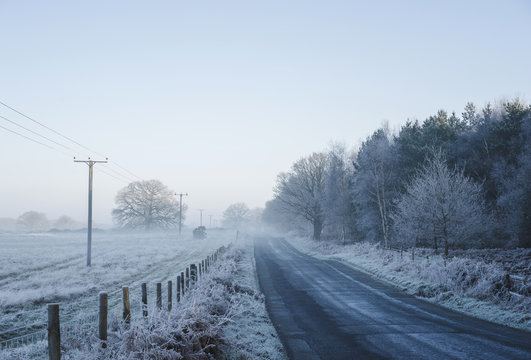 Icy rural road through mist.