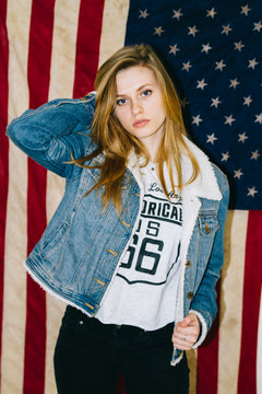 Portrait of young woman model posing in front of American flag