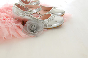 Vintage tulle pink chiffon dress and silver shoes on wooden white floor