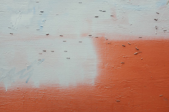 Staples and paint covering graffiti tags on urban wall, close up