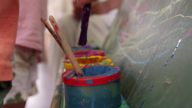 Close Up Of Paint Pots On Easel During School Art Lesson