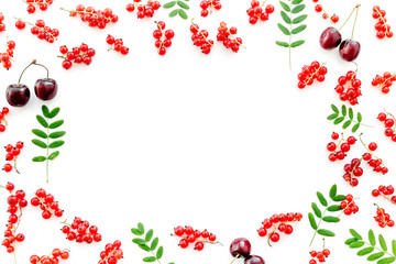 Berry frame. Red currant, cherry and leaves on white background top view copyspace