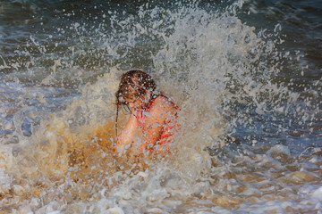 Little girl bathes in waves
