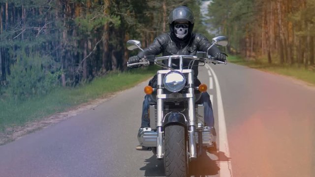 A black suited biker looks over and changes lanes. 