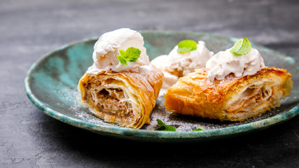 Strudel Apple and sugar powder. Biscuit from the puffed Test on the Gray Background. Dessert with Fruits. selective focus.