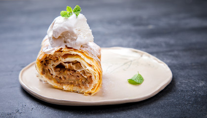 Strudel Apple and sugar powder. Biscuit from the puffed Test on the Gray Background. Dessert with Fruits.Copy space for Text. selective focus.