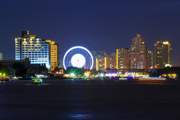 Fototapeta na wymiar Blur light of Ferris wheel at the amusement park in city / amusement park near the river