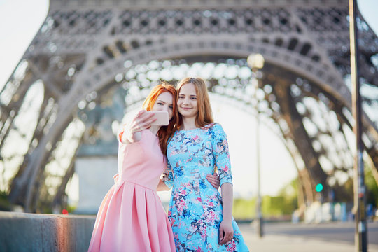 Two friends taking selfie near Eiffel tower in Paris, France