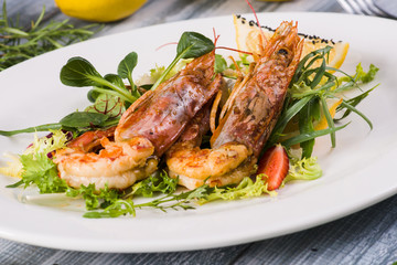  Fried shrimp with salad on a wooden background