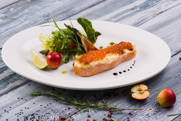  Steak from salmon wooden top background with red caviar
