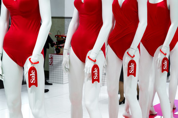 series of mannequins in red swimsuits. Sale