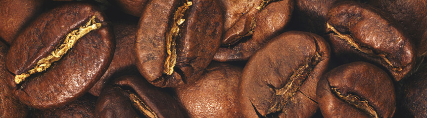 Obraz premium Coffee beans closeup on natural texture, border design panoramic banner. Vintage toned 