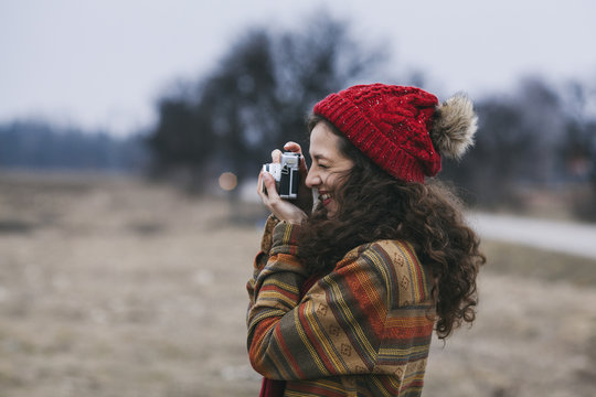 Young beautiful woman taking pictures in nature