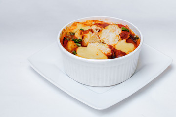 Baked vegetables zucchini and tomatoes with cheese. Isolated on white by clipping path.