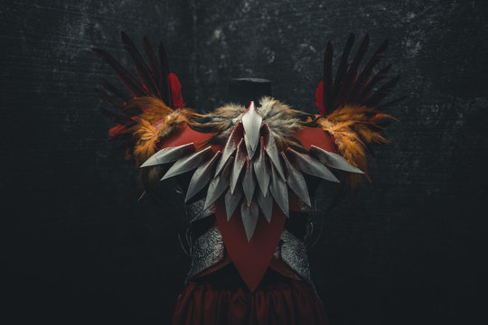 Back, Silver armor for women. Carries pieces of gold and fabrics and feathers in red color