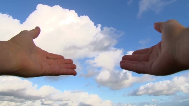 Hands covering camera lens reveal cloudscape turned time lapse.