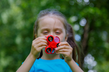Little girl is playing with two spinners