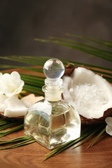 Platter with bottle of oil, coconut and palm leaf, closeup