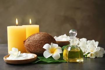 Beautiful spa composition with coconut body care products and candles on table