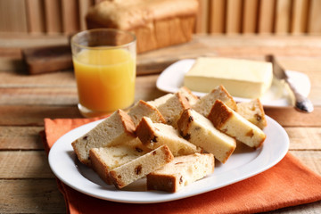 Ceramic plate with delicious sliced butter cake on wooden table