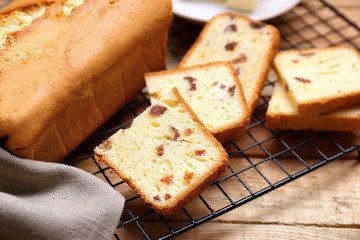Cooling rack with delicious butter cake on wooden table