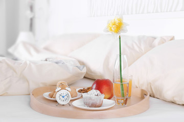 Fototapeta na wymiar Wooden tray with tasty breakfast on bed