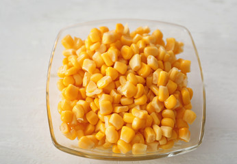 Plate with corn on white table, closeup