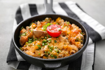 Frying pan with delicious turkey casserole on table, closeup