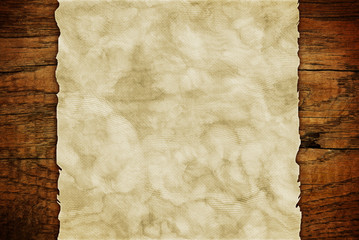 Grunge paper sheet on wooden wall or table in loft style