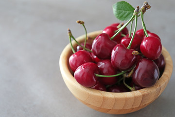 Bowl with fresh ripe cherries on table