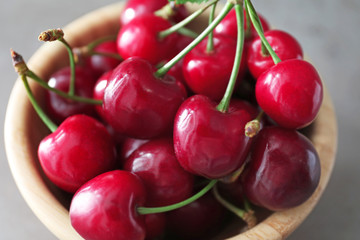 Bowl with fresh ripe cherries on grey background