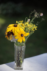 lato w ogrodzie - bukiet kwiatów na stole z białym obrusem