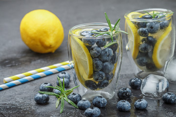 Refreshing summer drink with lemon, blueberries, rosemary and ice cubes. Detox, lemonade, cocktail....