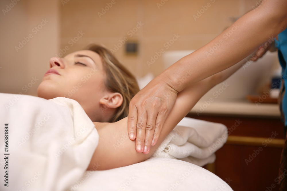 Wall mural Young woman having massage in spa salon, closeup view