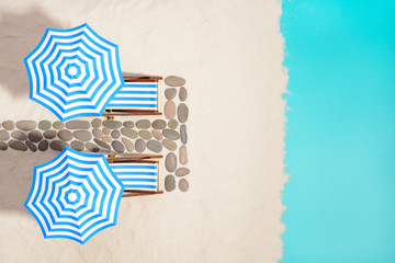 Beach furniture under umbrellas and pathway of stones