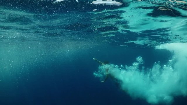 Jump into the water.
Young man jumping into the water. Underwater shot. Slow motion.