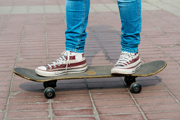 Skateboarder legs riding skateboard at street