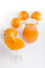 Glass jar and glass with orange juice.
