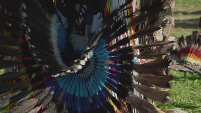 View of part of Peruvian dress made of feathers on true Peruvian playing flute and dancing outdoors