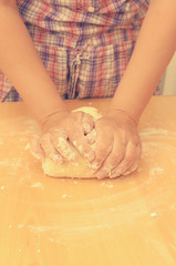 Obraz na płótnie Canvas A woman kneads a homemade dough for pizza production.