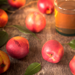 Peach compote in a glass with fresh nectarines on a wooden table
